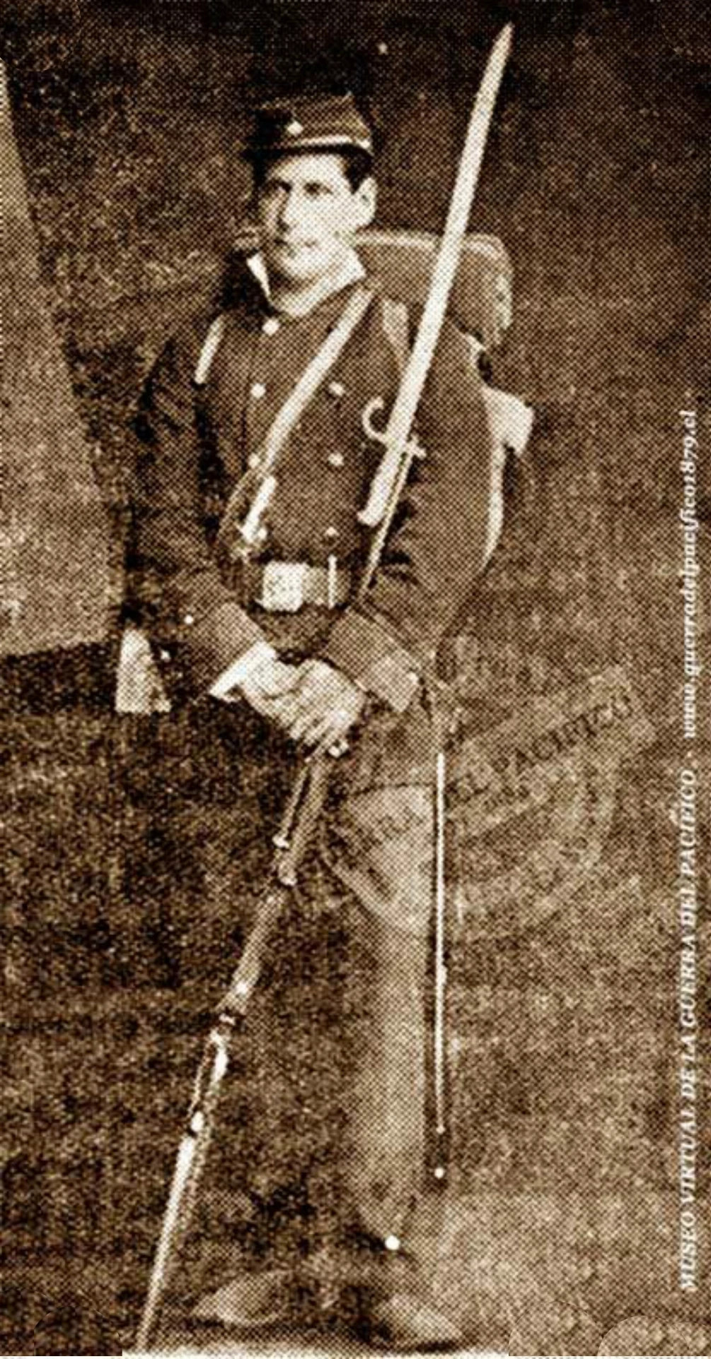 Sargento del Chacabuco, Policarpo Román, con sus elementos de batalla, uniforme, mochila, calamorros, bayoneta sable, calamorros de repuesto un  magnifico Corvo al cinto, cantimplora y su magnifico fusil Comblain  y su característico Quepi, el uniforme era Gris.